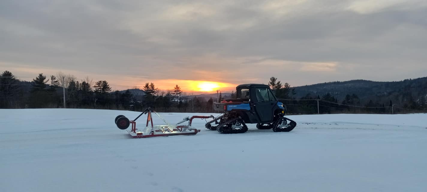WRR grooming equipment at sunset on a snow-covered field.